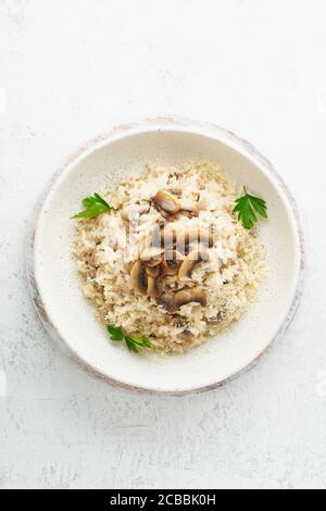 Risotto aux champignons dans l'assiette. Porridge de riz aux champignons et au persil Banque D'Images