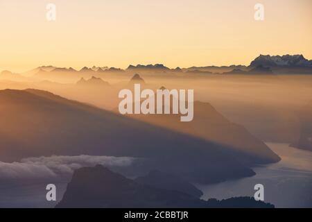 Vue panoramique sur le lac et les montagnes contre le ciel de moody pendant le beau lever du soleil. Lucerne, Suisse. Banque D'Images