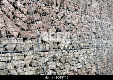 Mur en pierre construit de briques en béton et de mailles métalliques Banque D'Images