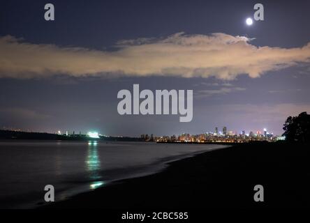 English Bay Night Vancouver Moon. La lune s'élève au-dessus de la ligne d'horizon de Vancouver sur la baie English. Colombie-Britannique, Canada. Banque D'Images