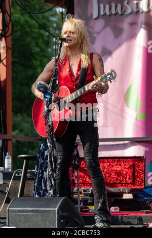 Michael Monroe sur scène avec guitare acoustique rouge au concert en plein air de Krapin Paja à Tuusula, en Finlande Banque D'Images