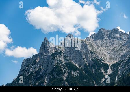 Pics de montagne des Alpes avec une végétation verte et le bleu ciel nuageux Banque D'Images