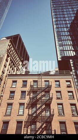 Ancienne maison en brique parmi les gratte-ciels modernes à New York, couleurs appliquées, Etats-Unis. Banque D'Images