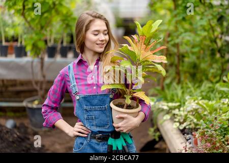 joyeux jardinier blond féminin avec un pot de fleur. gros plan photo.free temps d'activité. intérêt. Banque D'Images