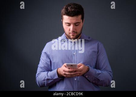 Portrait d'un jeune homme d'affaires élégant en surpoids barbu par téléphone Banque D'Images