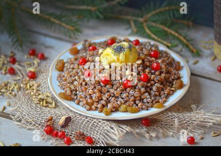 Pilaf sucré aux fruits secs. Kutia moderne aux fruits confits. Assiette avec kutia et fruits secs. Bouillie de Noël aux raisins secs, orange confite Banque D'Images