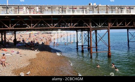 Brighton, Royaume-Uni - 10 août 2020 : beaucoup de gens sur la plage et dans la mer en profitant du temps chaud. Banque D'Images
