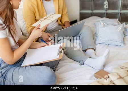 beau caucasien couple marié triant des lettres à la maison, ils planifient le mariage dans le mois futur, va envoyer des invitations à des amis et des parents. assis Banque D'Images