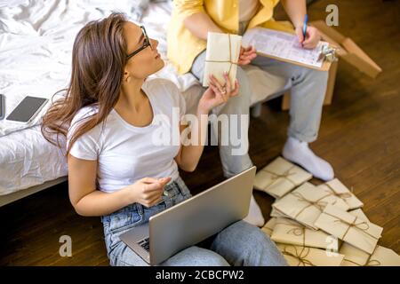 beau caucasien couple marié triant des lettres à la maison, ils planifient le mariage dans le mois futur, va envoyer des invitations à des amis et des parents. assis Banque D'Images