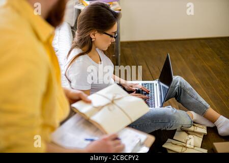 beau caucasien couple marié triant des lettres à la maison, ils planifient le mariage dans le mois futur, va envoyer des invitations à des amis et des parents. assis Banque D'Images