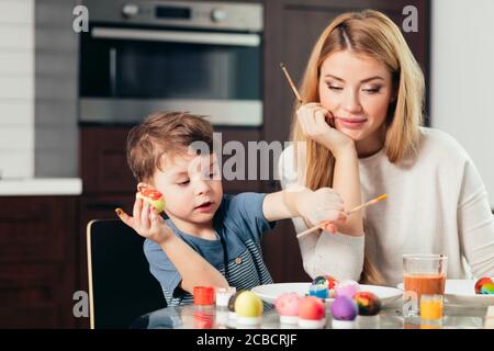 Jeune belle mère, qui était avec son fils, passer du temps ensemble. Célébration de Pâques et parentalité concept. La mère et le fils de décisions Easte Banque D'Images