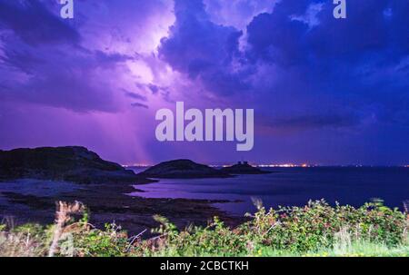 Mumbles Headland, Swansea, Royaume-Uni. 12 août 2020. La foudre en feuilles remplit le ciel nocturne de couleur au-dessus du phare de Mumbles à Bracelet Bay près de Swansea ce soir lors d'une pause par temps chaud. Credit: Phil Rees/Alamy Live News Banque D'Images