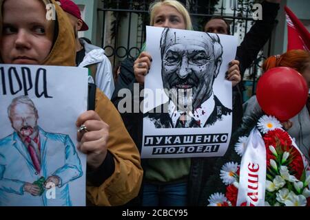 Moscou, Russie. 12 août 2020 des femmes tiennent des pancartes représentant le président biélorusse Alexandre Loukachenko devant l'ambassade biélorusse lors d'une protestation contre les résultats de l'élection présidentielle biélorusse, à Moscou, en Russie. La bannière se lit comme suit : « Loukachenko est un cannibal » Banque D'Images