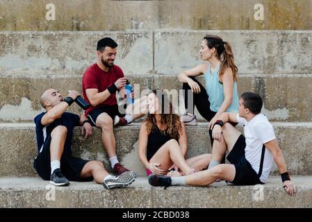 Groupe d'athlètes assis détendu après avoir pratiqué crossfit. Banque D'Images