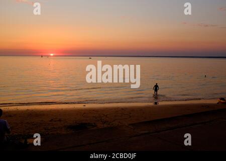 Nageur au coucher du soleil à Totland Bay sur l'île de Wight Banque D'Images