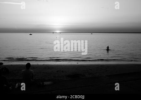 Nageur au coucher du soleil à Totland Bay sur l'île de Wight Banque D'Images