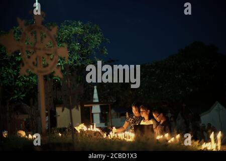 Larantuka, Indonésie. 2 avril 2015. Des dévotés et des pèlerins catholiques éclairant des bougies au cimetière de la cathédrale le jeudi Maundy, dans le cadre des célébrations de la semaine Sainte à Larantuka, sur l'île de Flores, en Indonésie. Banque D'Images