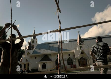 Larantuka, Indonésie. 1er avril 2015. Des membres de l'église congrégation travaillant ensemble devant la cathédrale de Larantuka le mercredi Saint, construisant une clôture en bambou comme plate-forme pour mettre des bougies pour les processions de la semaine Sainte à Larantuka, île de Flores, Indonésie. Banque D'Images