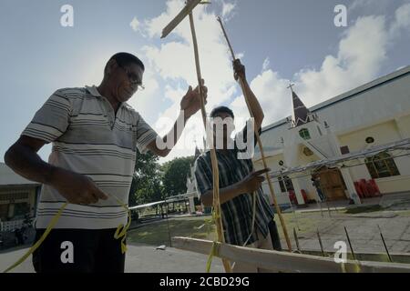 Larantuka, Indonésie. 1er avril 2015. Des membres de l'église congrégation travaillant ensemble devant la cathédrale de Larantuka le mercredi Saint, construisant une clôture en bambou comme plate-forme pour mettre des bougies pour les processions de la semaine Sainte à Larantuka, île de Flores, Indonésie. Banque D'Images