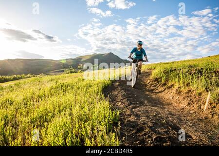 Une femme qui escalade le sentier sur Lewis Butte à l'extérieur de Winthrop, Washington, un après-midi ensoleillé en mai. Banque D'Images