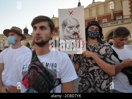 Cracovie, Pologne. 12 août 2020. Un manifestant tenant une image d'Alexandre Loukachenko qui a servi comme président de la Biélorussie depuis 1994, pendant la manifestation.des centaines de bélarussiens vivant à Cracovie et des partisans locaux se sont réunis pour un rassemblement de solidarité avec les manifestations bélarussiennes en cours, sur la place du marché de Cracovie, à l'extérieur du monument Adam Mickiewicz. Crédit : SOPA Images Limited/Alamy Live News Banque D'Images