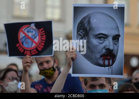 Cracovie, Pologne. 12 août 2020. Protesté tenant une image d'Alexandre Loukachenko qui a servi comme président de la Biélorussie depuis 1994, pendant la manifestation.des centaines de bélarussiens vivant à Cracovie et des partisans locaux se sont réunis pour un rassemblement de solidarité avec les manifestations bélarussiennes en cours, sur la place du marché de Cracovie, à l'extérieur du monument Adam Mickiewicz. Crédit : SOPA Images Limited/Alamy Live News Banque D'Images