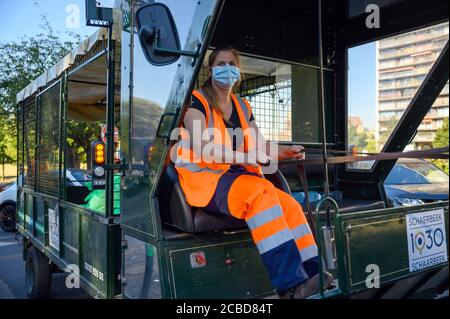07 août 2020, Belgique, Brüssel : Ludiviny Simon, chef d'équipe, dirige la voiture tirée par des chevaux du service de nettoyage dans le quartier Schaerbeek de Bruxelles. Depuis 2011, le service de collecte des déchets arrive six jours par semaine, non seulement avec les camions conventionnels, mais aussi à cheval et à chariot. Environ 200 poubelles publiques par jour sont vidées de cette façon. (À dpa 'camion de déchets avec sabots - amis à quatre pattes en action dans les rues de Bruxelles') photo: Sven Braun/dpa Banque D'Images