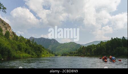 Rivière Iyus blanche au milieu des collines et des massifs rocheux. Les gens flottent sur le fleuve sur des catamarans. Russie, Khakassia. Banque D'Images