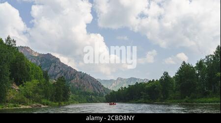 Rivière Iyus blanche au milieu des collines et des massifs rocheux. Les gens flottent sur le fleuve sur des catamarans. Russie, Khakassia. Banque D'Images