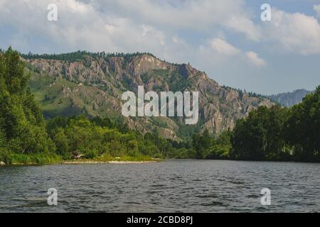 Rivière Iyus blanche au milieu des collines et des massifs rocheux. Les gens flottent sur le fleuve sur des catamarans. Russie, Khakassia. Banque D'Images