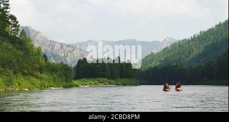 Rivière Iyus blanche au milieu des collines et des massifs rocheux. Les gens flottent sur le fleuve sur des catamarans. Russie, Khakassia. Banque D'Images