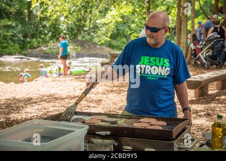 Des hommes grillent des hamburgers le long de la rivière Chattahoochee à Helen, en Géorgie, pour une réunion de famille à la fin d'une série de tubing sur la rivière. (ÉTATS-UNIS) Banque D'Images