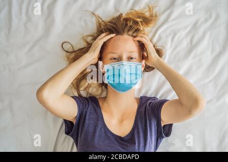 Jeune femme extrêmement fatiguée, couché sur le lit, à la maison seule. Auto-isolement à la maison, quarantaine en raison de la pandémie COVID 19. Problèmes de santé mentale en soi Banque D'Images