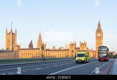 Londres, Royaume-Uni - 23 avril 2014 : une ambulance d'urgence se déplace sur le pont de Westminster au lever du soleil. En arrière-plan, le Parlement et la Tour Big Ben. Banque D'Images