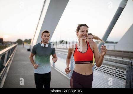 Athletic fit friends jogging ensemble à l'extérieur. Le sport, les amis, la santé concept Banque D'Images