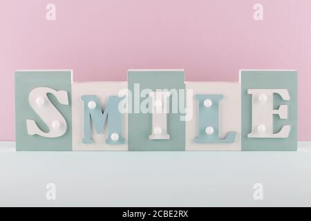 Mot Smile sur fond rose et bleu. Concept drôle Banque D'Images