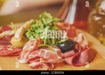 Carte de charcuterie avec jambon prosciutto, salami, herbes et antipasti aux olives. Plats gastronomiques Banque D'Images