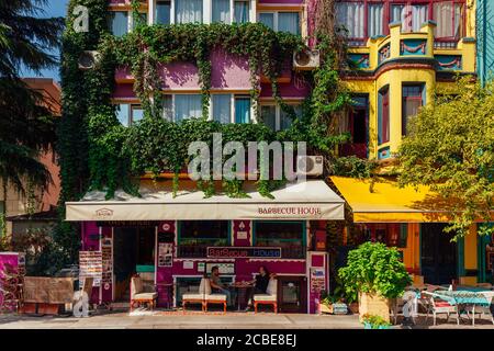 Istanbul, Turquie - 14 août 2018 : deux hommes dînent et parlent à la table devant une maison de barbecue dans la rue de Fatih à Istanbul, Turquie. Banque D'Images