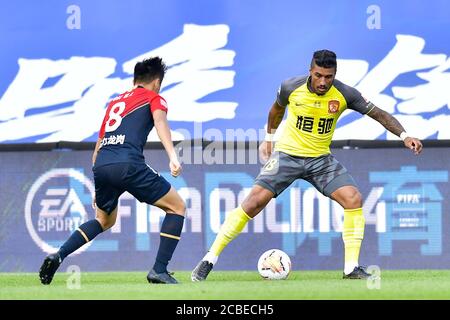 Le joueur de football brésilien Paulinho de Guangzhou Evergrande Taobao F.C., à droite, protège le ballon lors du match du troisième tour de la Super League chinoise 2020 (CSL) contre le F.C. Shenzhen dans la ville de Dalian, province de Liaoning, dans le nord-est de la Chine, le 4 août 2020. Guangzhou Evergrande Taobao bat Shenzhen F.C. avec 3-1. Banque D'Images