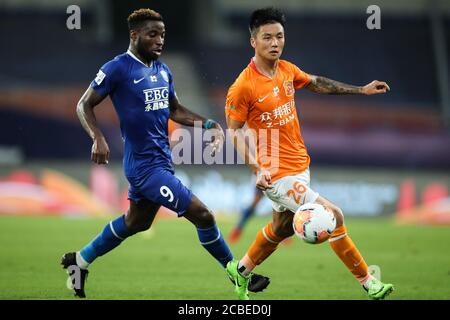 Le joueur de football congolais Oscar Maritu ou Oscar de Shijiazhuang toujours brillant F.C., à gauche, chase après le ballon pendant le troisième tour du match de la Super League chinoise (CSL) 2020 contre Wuhan Zall F.C., Suzhou ville, province de Jiangsu en Chine orientale, 7 août 2020. Wuhan Zall F.C. défait Shijiazhuang toujours F.C. brillant avec 2-1. Banque D'Images