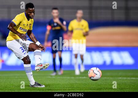 Le joueur de football ghanéen Moubarak Wakaso de Jiangsu Suning F.C. tire lors du quatrième tour de la Super League chinoise (CSL) 2020 contre la F.C. R&F de Guangzhou, ville de Dalian, province de Liaoning, dans le nord-est de la Chine, le 9 août 2020. Le F.C. R&F de Guangzhou a été battu par le F.C. Jiangsu Suning avec 0-2. Banque D'Images