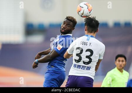 Le joueur de football congolais Oscar Maritu ou Oscar de Shijiazhuang toujours brillant F.C., à gauche, saute pour un ballon de tête lors du quatrième tour du match de la Super League chinoise 2020 (CSL) contre Tianjin TEDA F.C., ville de Suzhou, province de Jiangsu en Chine orientale, 11 août 2020. Le F.C. de Shenzhen a cassé le F.C. de TEDA de Tianjin avec 3-0. Banque D'Images