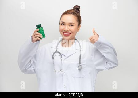 femme heureuse montrant pouce et tenant la bouteille avec des pilules Banque D'Images