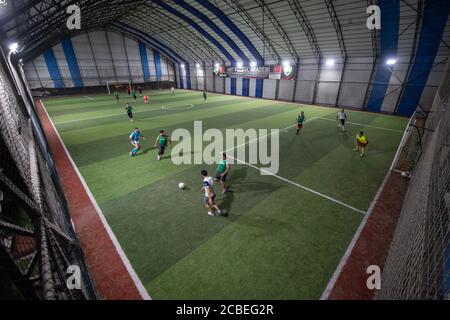 Istanbul, Turquie. 12 août 2020. Les gens jouent au football dans un stade intérieur après sa réouverture à Istanbul, Turquie, le 12 août 2020. Les autorités turques ont rouvert mercredi les terrains de football après cinq mois de fermeture dans le contexte de la pandémie COVID-19. Credit: Yasin Akgul/Xinhua/Alay Live News Banque D'Images