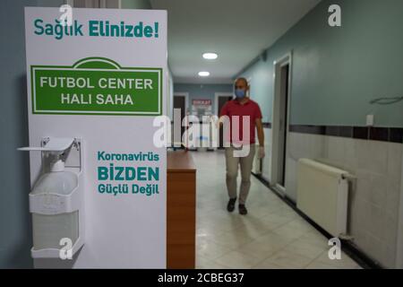 Istanbul, Turquie. 12 août 2020. Un membre du personnel désinfecte les installations d'un stade de football avant sa réouverture à Istanbul, en Turquie, le 12 août 2020. Les autorités turques ont rouvert mercredi les terrains de football après cinq mois de fermeture dans le contexte de la pandémie COVID-19. Credit: Yasin Akgul/Xinhua/Alay Live News Banque D'Images