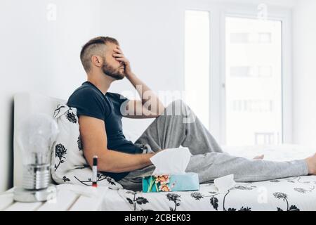 Jeune homme en quarantaine à domicile après un test Covid 19 positif Banque D'Images