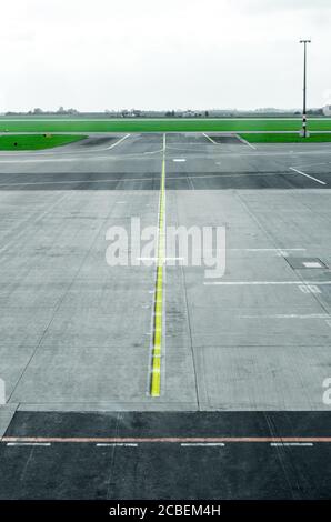 Tarmac de piste vide avec panneau de signalisation directionnel et de marquage, feux d'atterrissage et services à un aéroport commercial international Banque D'Images