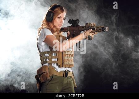 Femme sniper avec fusil de sniper SVD. Femme dans un soldat de l'armée américaine avec une carabine. Tourné en studio. Banque D'Images