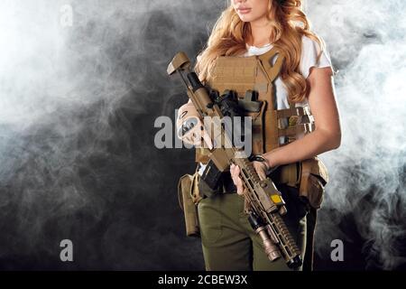 Femme dans l'armée pour et contre. Les femmes ne servent pas seulement, mais atteignent des postes et des rangs élevés. Belle femme dans l'arme militaire outfitholding dans han Banque D'Images