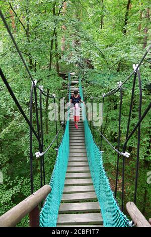 Serpukhov, Russie - 13 juillet 2020: Touristes sur le chemin de corde dans de la forêt dense. Pont de randonnée suspendu au-dessus de la partie basse de la forêt, passant par lui am Banque D'Images
